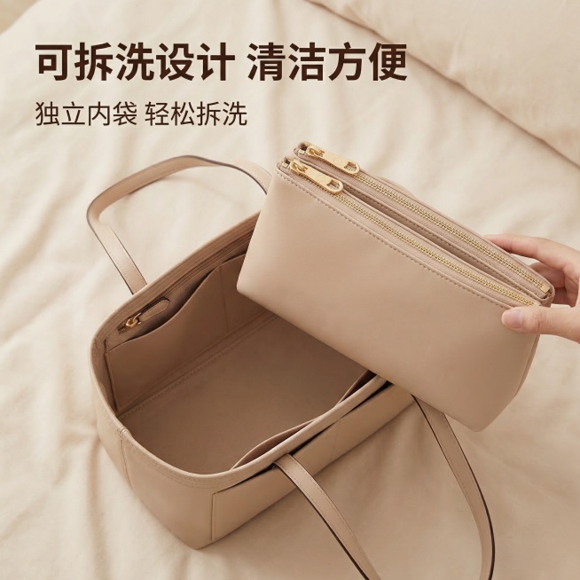 蔻驰MOLLIE托特包内胆包，主图主题：可拆卸拉链内袋设计，氛围风格：舒适简约 家居治愈，画面元素：展示独立可拆分的拉链内袋从内胆包中取出，平放展示，背景浅米色柔和干净，清晰呈现双拉链设计和独立结构，预览效果