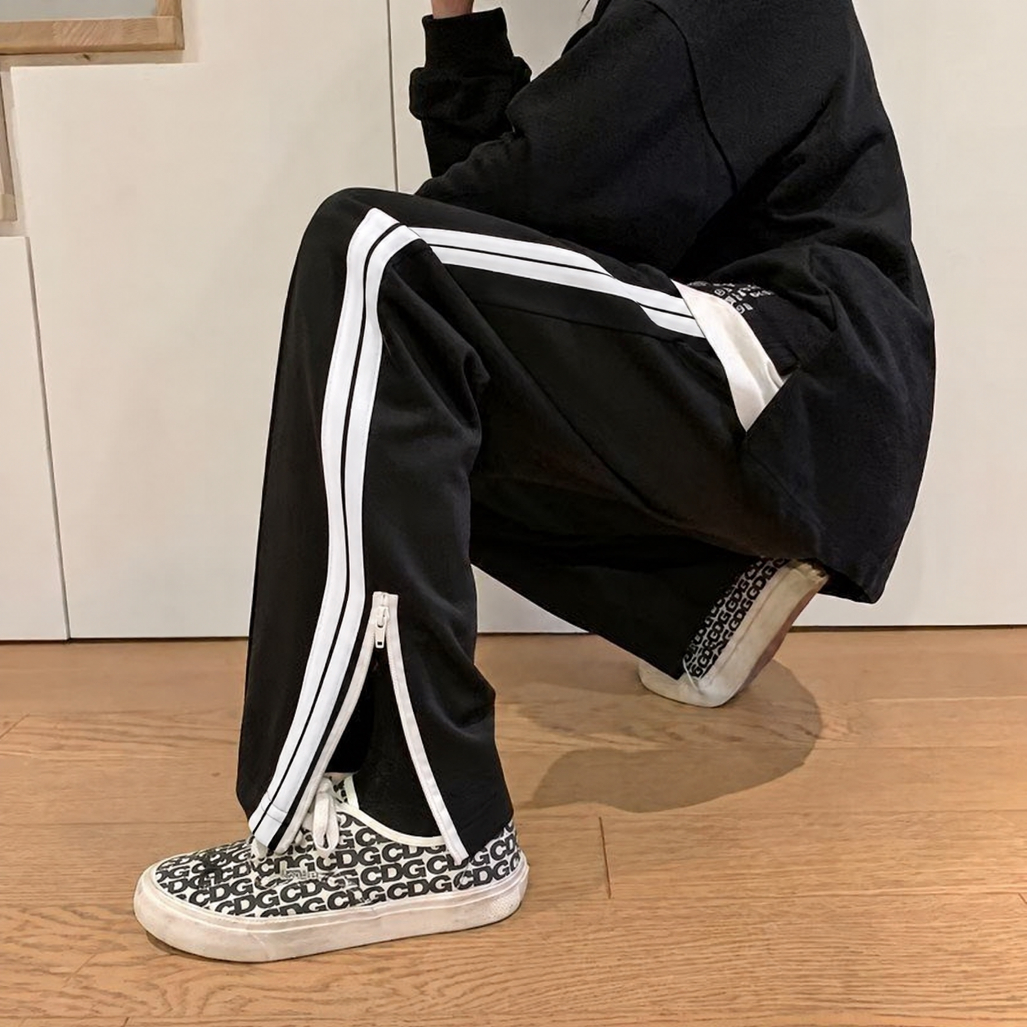 参考第一张图中黑色裤子侧边的白色织带样式，将第二张图模特裤子上… - 图片创意预览