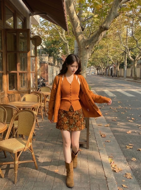 保留这套橘棕调秋日穿搭：针织开衫+针织吊带+碎花短裙，走动姿态展示穿搭的灵动效果，凸显衣服版型和整体搭配感，复古咖啡馆梧桐道午后暖光，慵懒秋日氛围感，抖音带货风格预览效果