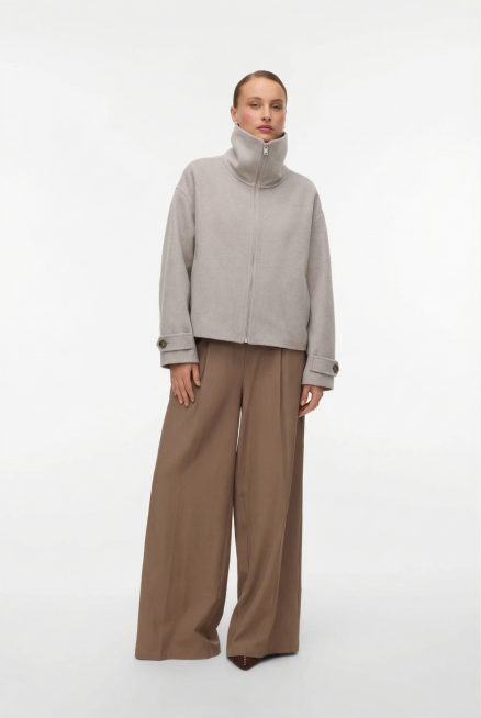 保持图二模特、卡其色阔腿裤和白色背景不变，将模特原来亮片上衣换成图一的浅灰色高领拉链短款外套，保持外套原款式和版型不变，自然穿着在模特身上。预览效果