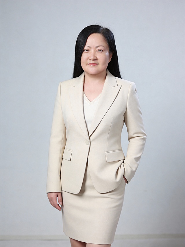 参考第一张图保留人物脸型､发型､年龄等特征生成职场形象照,参考第二张图人物占位和比例,标准焦段50mm,f/4光圈(f/2.8-f/4区间),平视视角(镜头与人物视线齐平);人物占画面60%,人物居中(居中构图),位于画面中心,为视觉聚焦点,入境范围头部及以下至臀部下方10cm(半身像);左右留少量背景空间;头部与画面顶部保留5%空间;头部发型完整,头肩比例协调;商务职场场景写真,平视视角,身穿修身精纺羊毛混纺面料的浅米色西装外套,平驳领设计(商务感正式感),西装处于扣好状态,领口可以看到米白色低领内搭边缘,下装同色系包臀半裙,长度至膝盖上方,版型修身贴合臀部线条,无多余装饰;发质柔顺微微光泽,自然职业妆(肤色白皙)淡妆,肤质白皙细腻;冷调白皙,极淡裸粉哑光眼影打底,极细内眼线填充睫毛根部,大直径深棕色带细微高光点的自然款美瞳;边缘模糊无生硬轮廓;眼神澄澈,看向镜头唇妆:自然水光唇釉,唇形饱满､唇峰清晰､唇面透亮光泽,左手插兜,右臂自然垂落,呈正面站立姿势,姿态从容;站立姿态轻松随性自然,面部正对镜头呈温和亲和感,眼神澄澈,看向镜头,表情自然,嘴角微微上扬,直视镜头;背景柔光布光光线均匀柔和;高清画质,浅景深处理,背景轻微虚化;商务清新质感,整体暖白色调､色彩饱和度中低､对比度柔和;整体氛围专业干练且温和亲和;自信从容;干练大气,主体锐利,明暗过渡柔和,背景光线均匀,简约浅灰度纯色背景(呈现均匀柔和质感),极简干净;32k画质超高分辨率､细节清晰,现代精致感风格;肤质精细化处理;微微修饰脸型,肤质哑光细腻,面部雾面柔光,轻透裸肌感,真实毛孔纹理,去除人物之外的所有元素｡严格按照第一张图内容生成｡