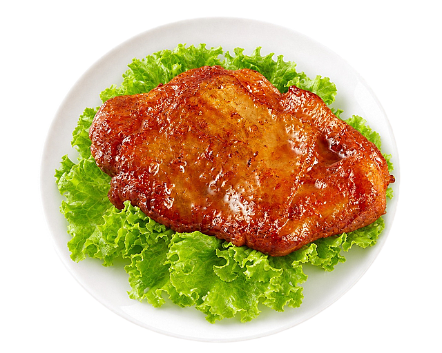将盘中的香煎鸡排放大，让鸡排占据盘子中央更大的面积，更加突出主体，鸡排的色泽、质感和生菜摆盘保持不变，白盘和背景透明保持不变。整体构图更饱满，鸡排更有视觉冲击力。