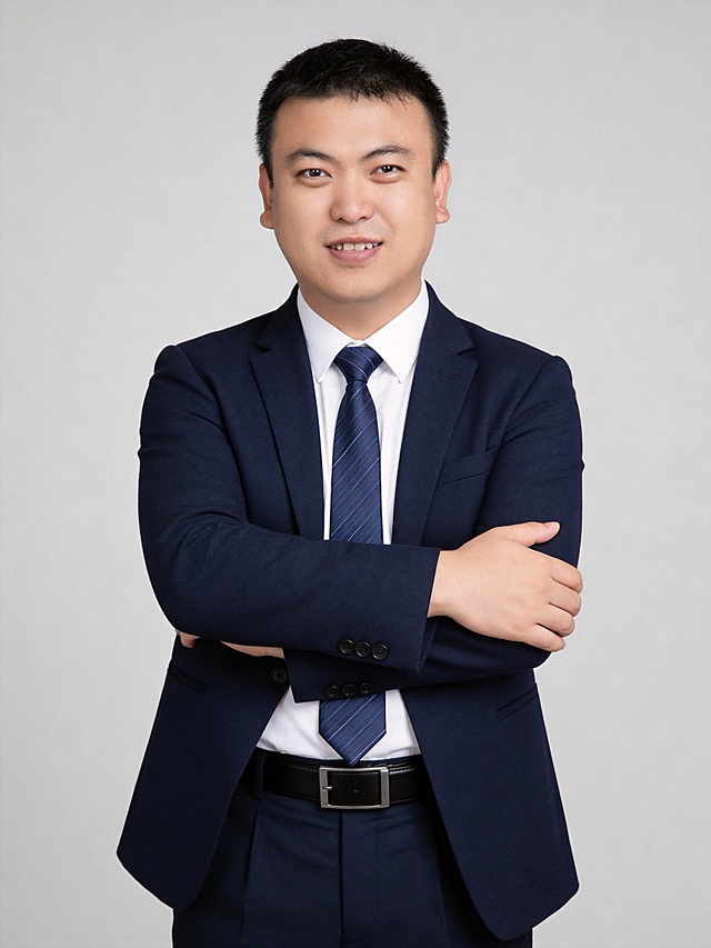 参考第一张图保留人物脸型､发型､年龄等特征生成职场形象照,参考第二张图人物占位和比例,标准焦段50mm,F/4光圈(F/2.8-F/4区间),平视视角(镜头与人物视线齐平);人物占画面70%,人物居中(居中构图),位于画面中心,为视觉聚焦点,入境范围头部及以下至臀部下方10cm(半身像);左右留少量背景空间;头部与画面顶部保留5%空间;头部发型完整,头肩比例协调;身穿精纺羊毛混纺面料的深墨蓝色西装外套(含5%桑蚕丝提升柔光质感),平驳领(商务感正式感),左胸袋无口袋巾(简化高级感),西装下摆自然垂度;内搭长绒棉白色衬衫(温莎领),袖口贴合手腕1cm(无堆叠);搭配精致且高级的深蓝色斜向微微渐隐光泽感极细条纹商务感领带(丝提花材质,低饱和柔光渐隐);下装精纺羊毛混纺面料的深墨蓝色高腰直筒西裤(面料同西装);搭配黑色哑光头层牛皮皮带(宽2.5cm),带扣为长方形拉丝黑色金属(1.8cm×3cm);呈正面抱胸的自然姿态,站立姿势:左臂搭于右臂上方,肩颈自然松弛下沉,姿态自信从容｡正式严谨专业稳重,身形匀称,姿态端正｡发梢微微修整干练大气,主体锐利,影棚侧光布光(主光来自画面前方),明暗过渡柔和,背景光线均匀,强化色彩对比的高级感｡哑光简约浅灰色纯色背景(呈现均匀柔和质感),极简干净;32K画质超高分辨率､细节清晰,整体风格雅致､兼具现代精致感;肤质精细化处理;眼神直视镜头,目光坚定且澄澈,表情自然.嘴角上扬;肌肤白皙透亮,柔光提亮,细腻无瑕,通透高级,干净清透肤质,肤色均匀,柔光美白细腻陶瓷肌肤,自然提亮,光影柔和通透水光肌,肤质细腻平滑干净哑光肤质,无油光无暗沉,肤色均匀提亮;杰作,最佳画质,超高细节,写实摄影,中近景人像,面部清晰,五官精致,皮肤细腻通透,白皙清透皮肤,干净肤色,健康肤色,无蜡黄,无暗沉,无黄皮,柔光,正面补光,面部光线均匀明亮,无浓重阴影,冷色调白平衡,画面干净清新,色调明亮,对焦清晰,肤质细腻,高清皮肤细节;面部光比1:1.5,4800K中性光,微微修饰脸型,肤质哑光细腻,面部雾面柔光,轻透裸肌感,真实毛孔纹理,32K画质,去除人物之外的所有元素｡