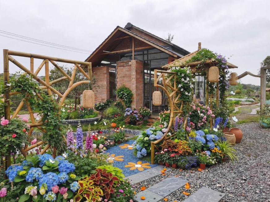 在图1（木质小屋+裸露草地与盆栽区）基础上，融合图2、3、4的多元园艺风格进行全景升级：保留房屋结构与位置完全不变；将全部空地与草地填满层次丰富的植物——包括蓝绣球、紫毛地黄、粉月季、彩叶草、观赏竹、预览效果