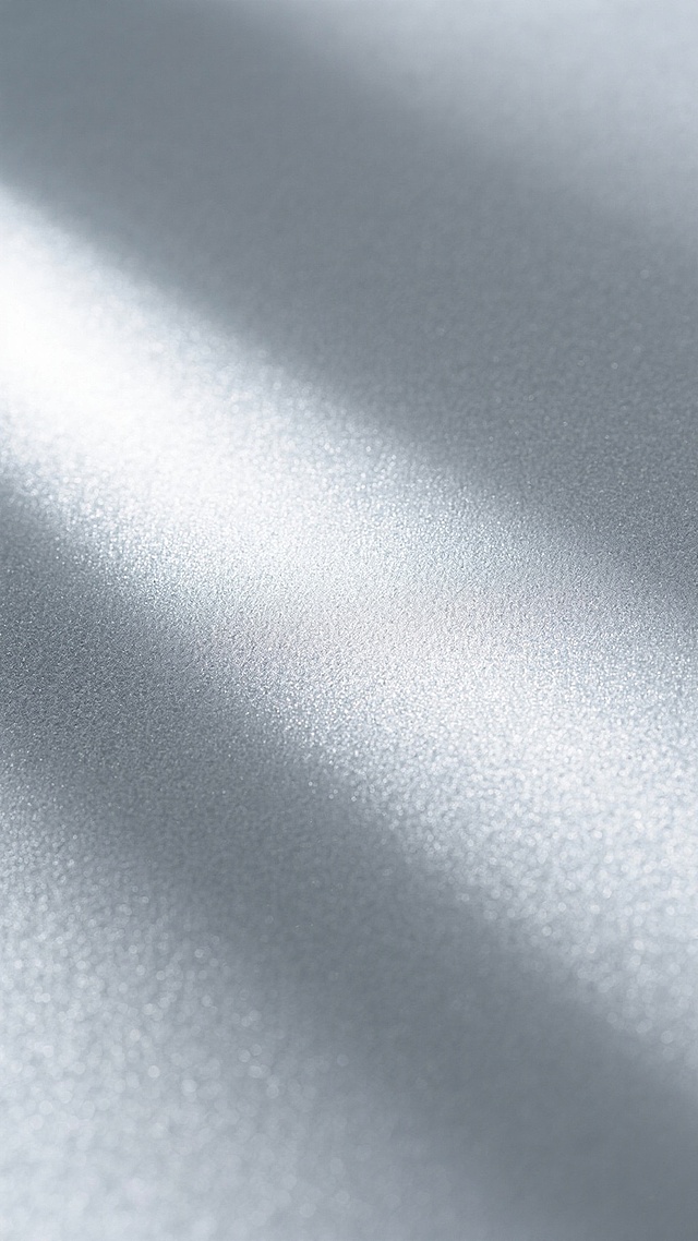 一张具有强烈金属质感的银白色背景图，表面呈现出细腻的磨砂纹理，整体色调从中心的亮银色向边缘自然过渡为稍暗的银灰色，光线从左上方柔和照射，在表面形成平滑的渐变光影效果，质感粗糙而均匀，没有任何图案、文字或装饰元素，仅展现纯粹的金属材质本身的独特肌理与光泽。