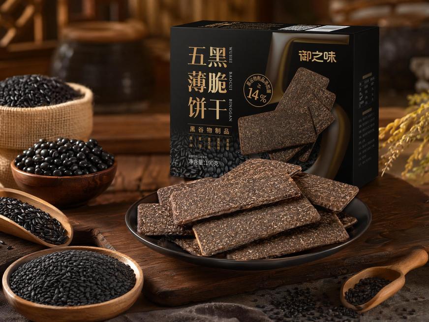 生成五黑薄脆饼干的全景电商场景图，保留饼干深褐色带谷物颗粒的质感，场景布置搭配黑芝麻、黑米等黑色谷物元素，暖调烘焙风格，整体构图展示完整产品全景预览效果