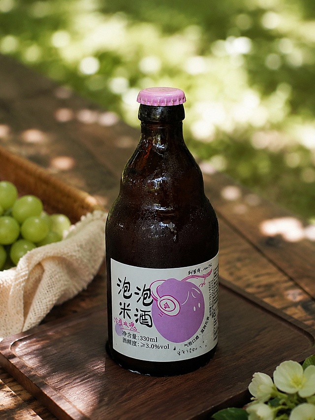 气泡米酒，严格参照上传产品图，完整保留所有可见组件、部件、轮廓形状、结构、比例、材质质感、颜色与产品本体上的文字信息，与上传图完全一致。
户外木质桌面野餐场景，自然治愈的森系暖绿色调。
产品放置于画面中心，侧前方柔和漫射自然光，产品受光面泛起暖绿环境色、暗部映射浅棕木质光晕，与环境物理融合。
微侧30°俯视视角，保持产品自然静态。
全量换款清单：①承载面：参考图苔藓 → 生成图深胡桃原木长方形餐垫；②背景：参考图室内玻璃空间 → 生成户外模糊树荫光斑。
参考相似度80%，消除额外品牌文字。
4K 分辨率，严格锁定宽高比为 3:4。