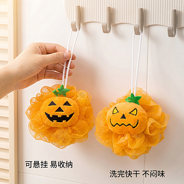 [主图-4]展示表情南瓜浴球便携悬挂使用场景。[氛围风格]可爱卡通风，生活化浴室场景。[画质]商业摄影质感，光线柔和通透，产品清晰真实，画面干净高级。[元素]一只手捏住浴球挂绳展示悬挂方式，两颗不同表情浴球并排悬挂在浴室挂钩上，背景是整洁的白色墙面，保持浴球表情外观颜色材质与输入图片绝对一致，杜绝任何变形和色差，精细化处理，商品主体占比约65%，画面满屏无边框。[光影]明亮浴室自然光，光线均匀柔和，真实生活感。[配色]浅米白色浴室背景，暖橙色浴球点缀，整体干净温馨。[视角构图]平视，主体居中，场景完整展示。[文字版式]左下角文字写"可悬挂 易收纳"，右下角补充"洗完快干 不闷味"，文字大小对比清晰，不遮挡产品主体。[比例分辨率]1:1比例，2K分辨率，文字清晰可辨，超高清。[负向提示词]变形，水印，文字错乱，产品图模糊，背景杂乱