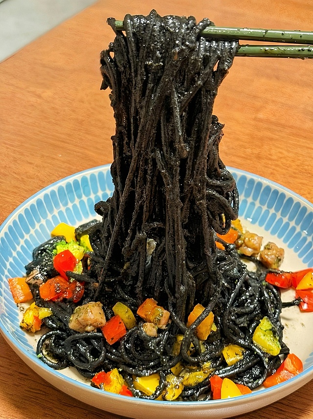 把图2意面里面的彩椒和海鲜块添加到图1的意面里面，注意要缩小再放进去，看起来更自然，不要覆盖在图1原本的彩椒上面，其余部分不要改动