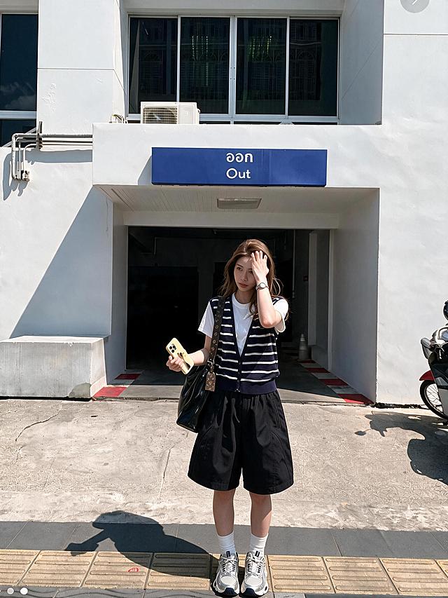 将图中女生的黑色短裤改短至膝盖中间位置，保持裤型、面料质感和整体画面风格不变，其余人物、背景、光影、服饰细节全部保留