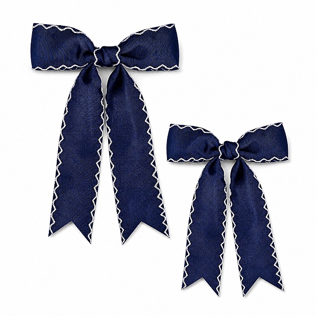 [主图-1] 2Pcs Wave Lace Edge Bow Hair Clips 亚马逊首图白底产品展示。
[统一基调] 亚马逊跨境风格，纯白背景，精致甜美儿童配饰风，无任何文字、水印、边框和装饰元素。
[画面] 画面中央展示2个藏蓝色波浪蕾丝边蝴蝶结发夹，上下错落摆放，上方一个稍大偏左，下方一个稍小偏右，形成自然的层次感。发夹为罗缎材质，蝴蝶结边缘有白色波浪形蕾丝锁边，下方两条长飘带呈燕尾形剪裁，飘带边缘同样有白色波浪蕾丝边。产品完整展示，不裁切，主体占画面约85%。发夹呈现自然的立体感，蝴蝶结饱满，飘带自然垂落。
[光影质感] 商业摄影棚拍质感，柔和均匀的主光从左上方照射，右侧有轻微补光，发夹下方有柔和的接触阴影，体现产品的立体感和真实存在感。罗缎材质呈现细腻的织物质感，白色蕾丝边清晰精致。
[配色] 纯白背景，藏蓝色发夹主体，白色蕾丝锁边，整体干净清爽。
[输出要求] 1:1正方形比例，2048x2048像素，产品清晰锐利，边缘干净无杂边，无变形、无模糊、无水印、无平台Logo、无任何文字。