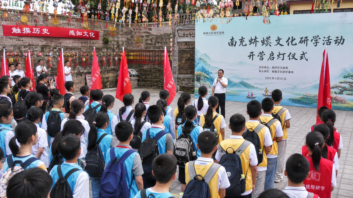 南充蛴蟆文化研学活动开营启灯仪式，研学基地广场上，人群整齐列队分组，导师致辞，授非遗传承小队旗，现场悬挂端午五彩绳，文化氛围浓厚，写实风格，清晰明亮预览效果
