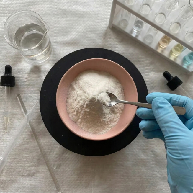 帮我为这个产品，生成周围有一些化学器材，然后一只戴着浅蓝色硅胶手套的收拿着勺子准备去勺他，视角保持不变预览效果