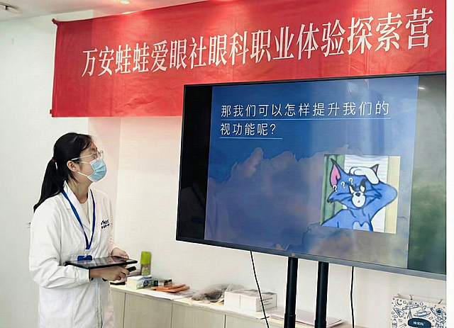 红色条幅上加入白色文字“万安蛙蛙爱眼社眼科职业体验探索营”