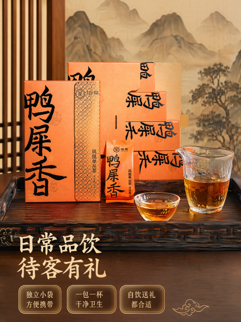 [主图4-场景体验]中茶鸭屎香凤凰单丛茶，保持原产品包装外观一致。展示泡茶使用场景，产品礼盒放置在深色实木茶盘上，旁边摆放玻璃公道杯和品茗杯，茶汤橙黄透亮。背景为原木茶室墙面，搭配淡淡的国潮水墨远山装预览效果