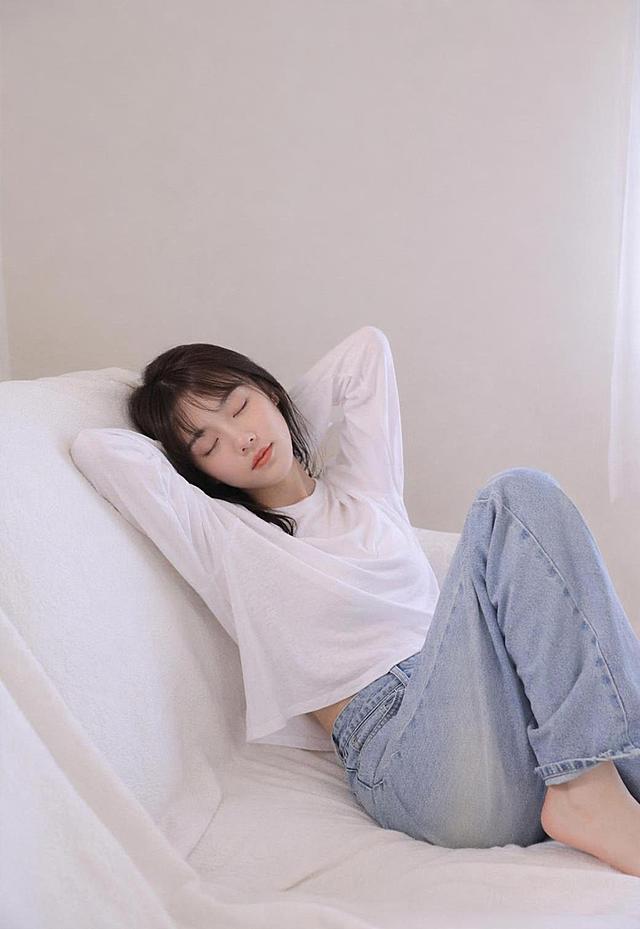 参考原图风格，生成少女居家可爱写真，温柔浅色系氛围，闭眼放松姿态，简约干净背景