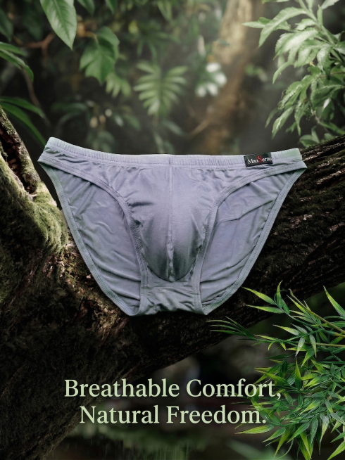 保持原图产品主体ManSerno灰色男士三角内裤结构和Logo不变，将英文广告语'Breathable Comfort, Natural Freedom.'添加在图片下方位置，保持整体自然森林背景风格预览效果