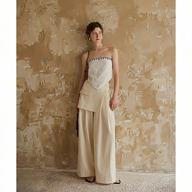 保留图中人物服装，替换为和第一张参考图一样的真实自然高级感暖棕色做旧墙面背景，去除图片上的文字水印，保持整体高级自然质感