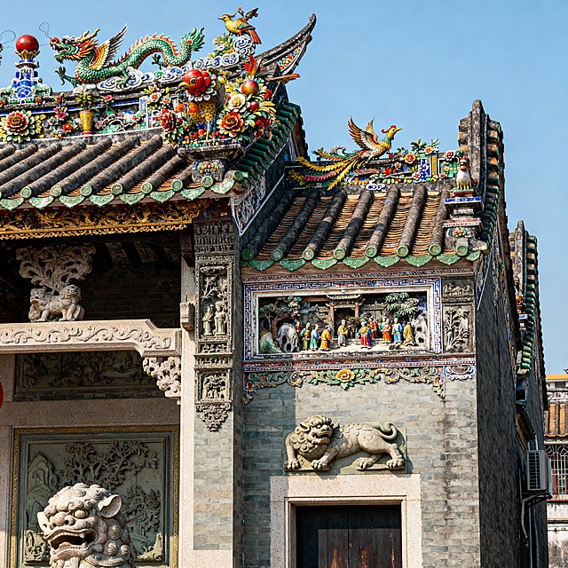 帮我生成一张下山虎，四点金的图片，体现潮汕当地的建筑特色以潮汕嵌瓷工艺为视觉核心的“下山虎”建筑图，屋顶龙凤、花鸟嵌瓷造型立体饱满，色彩浓艳有光泽，墙体刻潮汕祠堂常见的石雕瑞兽，