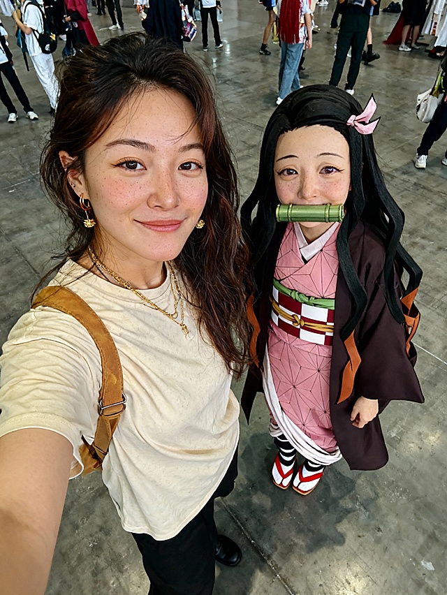 图一人物和图二角色的真人coser，在漫展里合拍，没有其他人，俯拍视角，光线明亮。