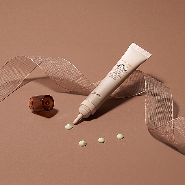 浅米色管状眼霜产品，带棕色盖子，管口挤出四滴浅绿膏体。保持产品外观、文字Logo和结构完全不变，不得扭曲变形。极简干净暖棕色台面场景，留白充足，低饱和度暖棕色调，搭配浅棕色半透网状丝带装饰。柔和散射漫射光，光影自然，产品质感高级，8K高清画质，严格锁定比例1:1，极简高级美学风格。