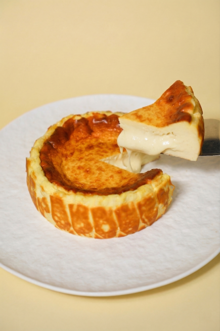 减少巴斯克蛋糕流出的流心量，只稍微减少一些，不要完全去掉流心，保持蛋糕其他部分和原图一致，保留整体构图、色彩和光线预览效果