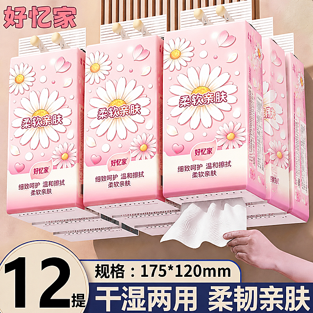 将图中所有悬挂式面巾纸包装的图案全部替换为第一张白底图中的粉色雏菊包装设计，保留包装的悬挂结构、抽纸形态和整体场景布局不变。替换内容包括：粉色渐变底色、白色大雏菊花朵、粉色小雏菊、花瓣装饰、圆点、爱心元素，以及"柔软亲肤"、"好忆家"、"细致呵护 温和擦拭 柔软亲肤"等全部文字内容，文字位置和排版参考第一张白底图。保持场景中的墙面、挂钩、手、抽纸、底部文字信息条等其他元素完全不变。