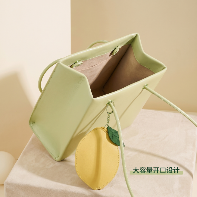 [主图 3] 包包侧面细节和容量展示。[氛围风格] 高级松弛感，生活化清新简约室内场景。[画质] 商业摄影质感、光线柔和通透、产品清晰真实、画面干净高级。[元素] 浅绿色方形包包侧开放置，展示包包开口预览效果