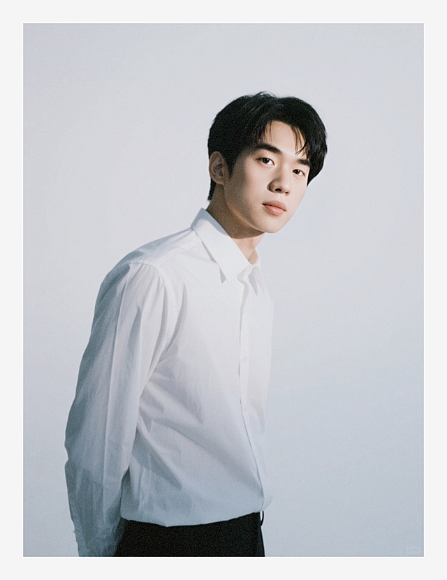 一个五官成熟男生，白色背景，强曝光低饱和，截腰半身照，穿着得体，高级感