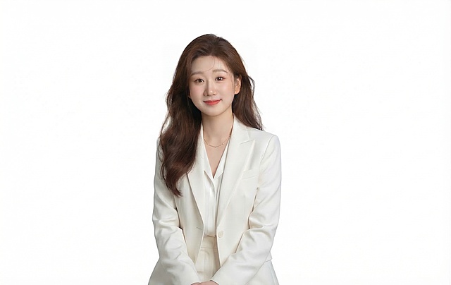 对整张图进行专业级修图：提升画面干净度与通透感，优化肤色均匀性与光影层次，增强西装质感与背景纯净度，严格保持人物面部妆容、表情、发型及姿态不变