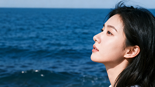 高清海边写真，人物侧脸朝向深蓝色大海，画面简洁便于后期添加文字，清新自然风格，细节丰富