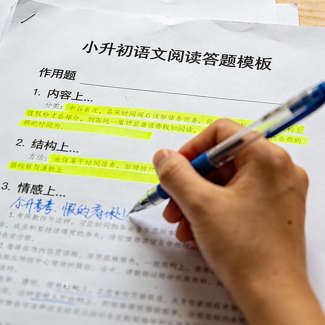 Close-up of printed handout: "小升初语文阅读答题模板". Shows filled example for "作用题": 内容上... 结构上... 情感上... Yellow highlights, blue pen notes. Looks like real parent-used material.