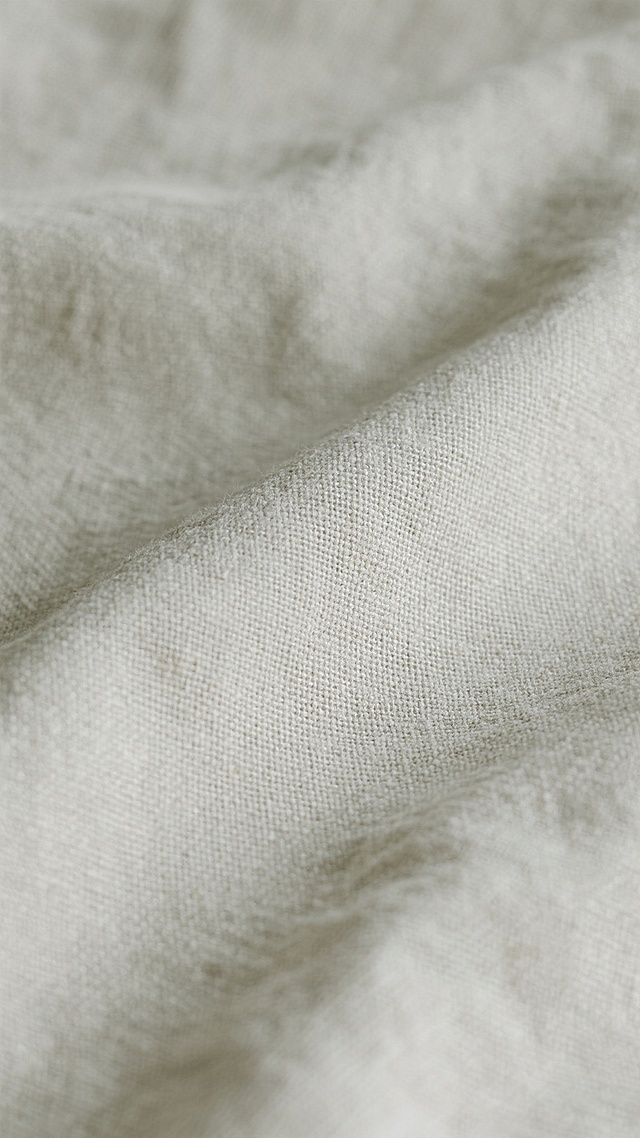 布主题背景，具有细腻纹理的亚麻布料质感，经纬线交织形成规则的细小网格图案，整体呈现柔和的浅灰色调，光线均匀照射，阴影细微，表面平滑略带自然的织物褶皱感，无明显光泽，简约而富有自然肌理的背景。