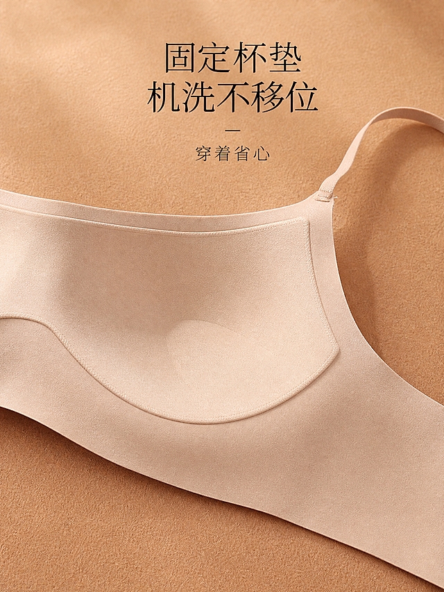 高级商业棚拍，裸肤色无痕一片式细肩带内衣，内侧杯垫结构特写。内衣内侧朝上平铺，展示杯垫一体式固定结构，杯垫与内里缝合固定，不移位。奶茶棕绒面背景，45度俯拍特写，暖调柔和光线，面料哑光质感。画面上方黑色文字「固定杯垫 机洗不移位」，下方小字「穿着省心」。3:4竖版，2K高清，杯垫结构清晰，材质真实，文字清晰，画面干净。