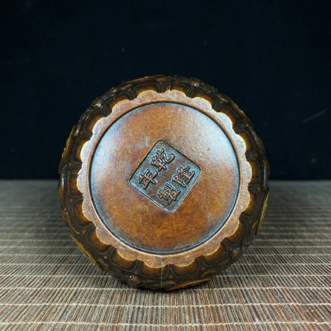 铜香炉底部展示，摆放在古朴的竹席案桌上，保持原图片的滤镜和棕褐色调一致，保持铜质温润光泽，光影自然，传统古典风格，不改变香炉底部原有印章和雕刻细节预览效果
