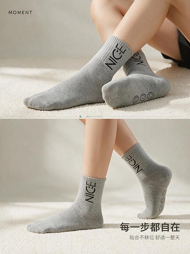 [商品] 使用【图2】浅灰色竹爱NICE女袜中筒袜多角度姿态；商品处理：保留袜底三枚笑脸图案、"NICE"提花、浅灰色、针织纹理和中筒版型；自然理顺袜身，增强面料质感，不改变版型、颜色和结构。
[画面] 页面目标：多姿态上脚展示，呈现行走/抬脚等动态下的贴合度与舒适感。上下拼贴构图，上方约50%为双脚交叠坐姿，展示袜底笑脸细节与袜子背面效果；下方约50%为行走动态脚部特写，展示袜子正面与侧面贴合效果。两张图均为同一亚洲模特、同一浅灰色袜子、同一米白编织地毯背景，保持视觉统一。中间用细线+小号英文装饰分隔。
[视觉] 套系策略：风格=简约高级日系商业摄影；标题字=现代无衬线粗体（思源黑体Heavy）；正文字=简洁无衬线体（思源黑体Regular）；主色=浅米灰+麻灰；背景延展=基于浅米灰做深浅层级、同色渐变和细腻织物/哑光墙面质感；强调色=竹青绿，仅用于小面积图标、引线和标签点缀；标题色=深炭灰；正文色=中暖灰；组件=细线分隔、小号英文装饰、圆角标签；光影=左前侧柔和自然光，上下图光线统一。
[文字] 画面左上角小号英文装饰"MOMENT"，右下角主标题小字"每一步都自在"，下方一行更小字副标题"贴合不移位 舒适一整天"。文字量少，以画面展示为主。文字全部横排。
[规格] 图片比例3:4竖版（移动端详情页），分辨率1K，避免变形、错字、文字过小、冷蓝背景、袜子颜色改变、版型失真、低俗擦边、极限词。