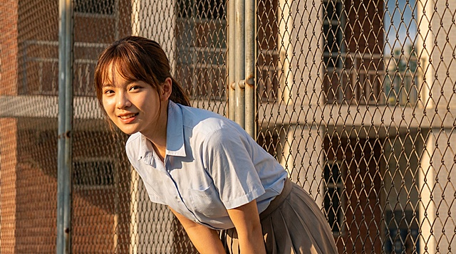 将线稿完善为摄影写实风格，人物保持原有的动作姿态和角度不变，晴朗的初夏下午5点，从拍摄者角度看去，阳光正面照射在女生身上，女生的面部和身体都被阳光照亮，形成顺光效果，整体画面具有纪实摄影的质感和光影层次