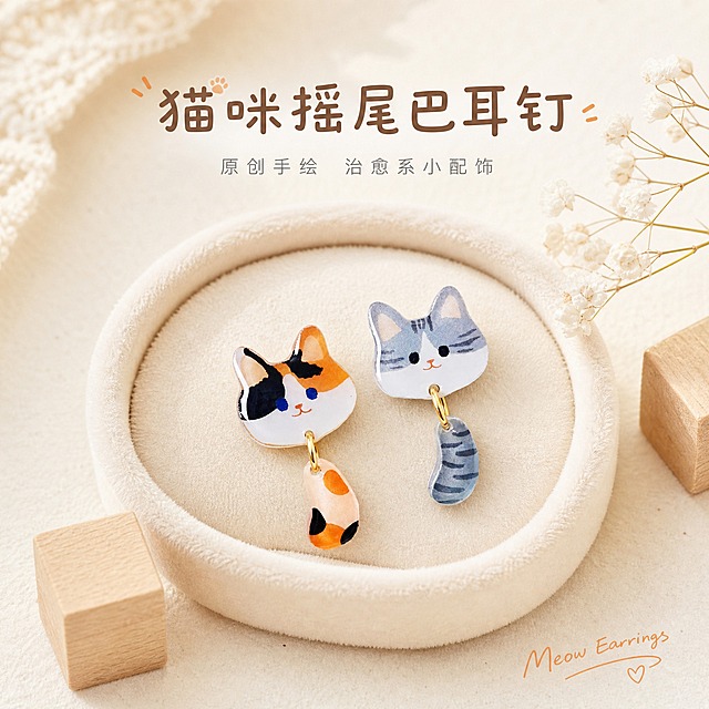 [主图-1] 主题：可爱猫咪摇尾巴耳钉 首图氛围展示，突出产品整体造型与治愈感。
[统一基调] 日系清新治愈风格，奶油米白浅色系背景，整体柔光干净，字体用文艺细圆体，标题字色暖棕，辅助字色浅灰，强调色橘橙色，整体精致手作感，无厚重色块。
[画面] 画面中央展示三花猫耳钉与银灰猫耳钉各一只，耳钉为猫咪头+可晃动小尾巴的滴胶亮面造型，猫咪头圆润可爱，尾巴通过金色小挂环自然垂落微微晃动。耳钉放置在浅米色绒布小托盘上，旁边点缀一小枝白色满天星干花和原木小方块，营造温柔手作氛围。产品占画面约60%，居中偏上，视角为45度俯拍，耳钉细节清晰，滴胶表面有柔和高光反光，金属挂环为金色亮面。
[光影质感] 顶部柔光箱主光，左侧辅光，右侧柔和阴影，整体光线均匀通透，滴胶材质呈现通透亮面质感，边缘清晰无毛刺，金属挂环有细腻高光，底部有自然接触阴影，无悬浮感。
[配色] 背景奶油米白色，点缀浅木色与白色花艺，产品本身橘色、灰色、黑色、白色猫咪配色，金色挂环点缀，整体暖调清新。
[文字版式] 画面上方居中主标题「猫咪摇尾巴耳钉」，字体文艺细圆体加粗，暖棕色；主标题下方小字「原创手绘 治愈系小配饰」，浅灰色细体，字号为主标题的50%。画面右下角小号手写体英文「Meow Earrings」，浅橘色，装饰用不抢主体。文字均放在负空间，不遮挡耳钉主体。
[输出要求] 1:1正方形，2K分辨率，文字清晰锐利，产品细节清晰，无变形错字，无水印无平台Logo，背景干净整洁，整体氛围温柔治愈。