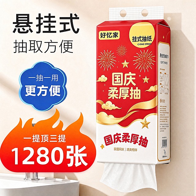 将图中悬挂式面巾纸盒的外包装替换为参考白底图的完整国庆红金主题设计：包装上半部分为大红色底、下半部分为白色，正面铺满金色烟花、五角星、祥云和金色缎带装饰，左上角黄色圆角框内'好忆家'品牌，右上角黄色圆形'挂式抽纸'及英文，中央大号金字'国庆柔厚抽'，下方'家国同庆|清爽相伴'，与参考图风格完全一致。保留原包装盒型、顶部挂孔、悬挂状态和侧面使用说明图案。保持原有场景完全不变：浅米色墙面、浴室台面、纸巾悬挂位置、左侧营销贴片（悬挂式抽取方便、一抽一用更方便、一提顶三提1280张）、光线、透视角度和构图不变，注意图案在盒面的透视变形与光影细节