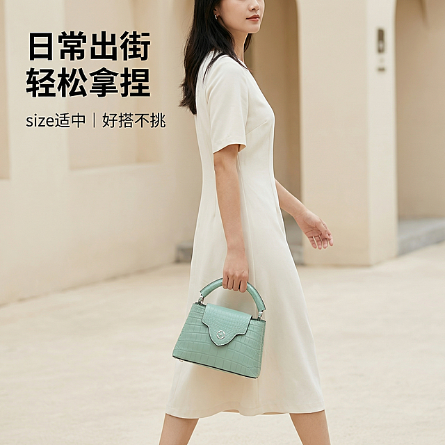 [主图4] 模特上身场景展示
[主图主题] 薄荷绿手提包日常穿搭展示
[氛围/风格] 精致舒适氛围感，日常高奢街拍风
[画面元素] 一位亚洲女性模特，身着简约米白色连衣裙，手拿薄荷绿鳄鱼纹手提包自然行走在干净极简的米色街道背景，包包自然垂在身侧，整体姿态自然放松，保持包包外观和颜色与原图一致，光影柔和自然，突出包包上身效果
[配色色系] 主薄荷绿包包，米白色服饰，浅米背景
[视角构图] 中景构图，模特从腰部以上入镜，包包在视觉中心位置
[文字版式] 左上角标题 "日常出街 轻松拿捏"，小号字标注 "size适中 | 好搭不挑"，文字简洁不遮挡模特和包包主体，无底色直接悬浮
[比例分辨率] 1:1比例，2k分辨率
