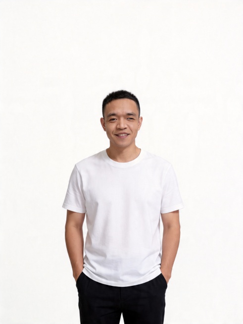 生成男士生活写真，仅保留参考图人物脸型、五官、发型、年龄特征不改动，换装为白色圆领短袖T恤、黑色长裤，人物站姿站立，双手插兜，自然微笑，背景更换为纯白色，风格简约干净，高级质感，光线均匀柔和，4k分辨预览效果