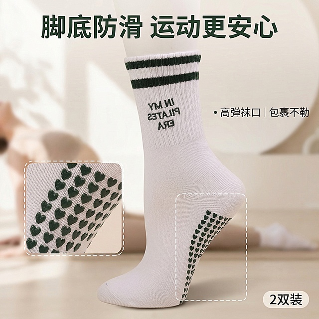 [主图主题] 瑜伽袜防滑功能卖点展示
[氛围/风格] 同上清新明亮风格
[画面元素] 墨绿条纹款瑜伽袜居中，底部微距特写爱心防滑点，用白色虚线标注防滑点区域，背景为浅米色瑜伽动作场景局部，光影柔和
[配色色系] 主色调：米白+墨绿；辅助色：浅肤色
[视角构图] 平视，产品占画面55%，焦点突出防滑点细节
[文字版式] 顶部主标题“脚底防滑 运动更安心”，右下角“2双装”标签，侧边悬浮卖点“高弹袜口 | 包裹不勒”，无衬线深绿色字体，文字悬浮不遮挡产品