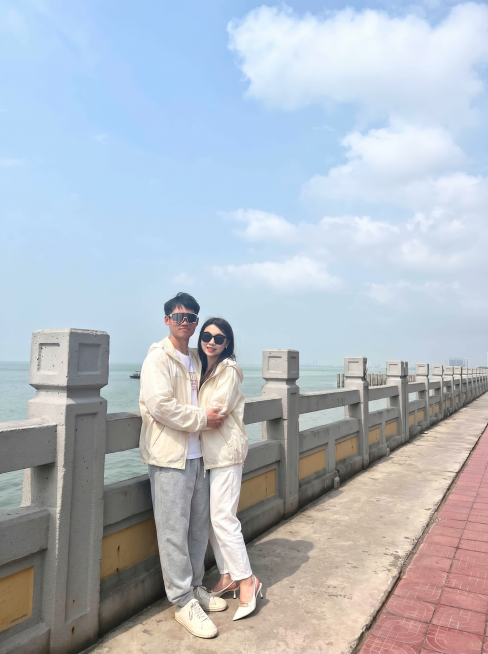 将图2的米白色连帽外套分别穿到图3这对情侣身上，男女都换上这件外套，替换掉原来的衣服，过渡自然平整，保持原来的海边护栏背景和人物拥抱姿势，图片比例3比4预览效果