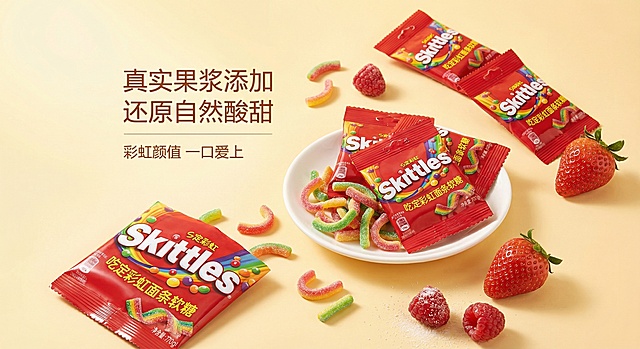 打造温馨治愈风格主图，背景用柔和的暖黄色渐变，展示多包箭牌彩虹面条软糖和散落的软糖，搭配新鲜的草莓、树莓水果点缀，添加卖点文字“真实果浆添加 还原自然酸甜”“彩虹颜值 一口爱上”，画面温暖有食欲