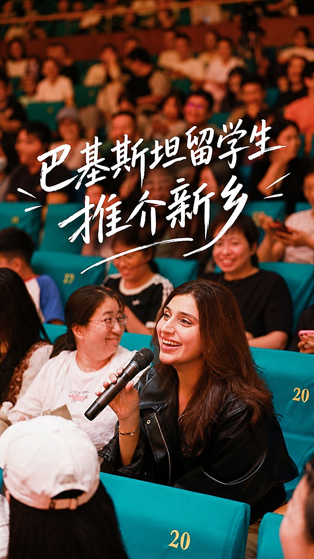 基于这张观众席的照片制作9:16竖版视频封面，保留原图人物和场景，在画面正中间添加大号白色手写风格文字："巴基斯坦留学生推介新乡"。文字为随性自然的手写风格，充满灵动与艺术感，笔画线条流畅且富有变化，粗细不一，笔触灵动洒脱，部分笔画较为纤细轻盈，似信手拈来，给人轻松洒脱之感，仿佛是作者在自然状态下快速书写而成，传递出自由洒脱且富有诗意的氛围。文字具有设计感，字号要大，位于画面正中央，清晰醒目。整体画面保持电影感暖色调，氛围轻松愉悦。