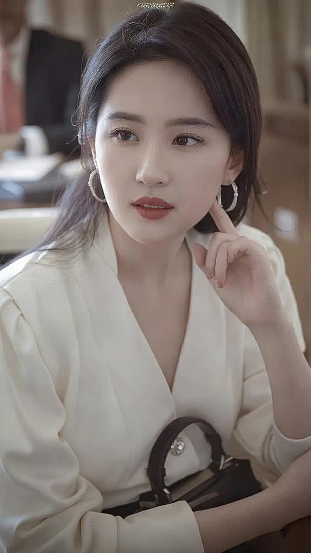 女生坐在椅子上，嘴角略带邪魅的微笑，希区柯克式缓慢变焦。