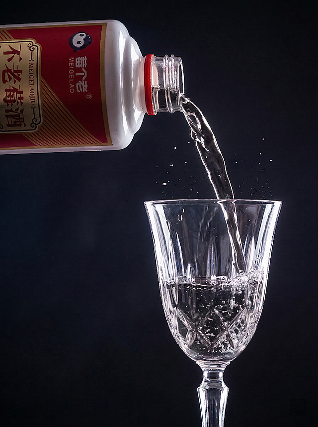 把图中正在倾倒的紫红色酒液和玻璃杯里的酒液都改成清澈透明的白酒模样，保持其他所有元素完全不变，只修改酒液颜色和质感