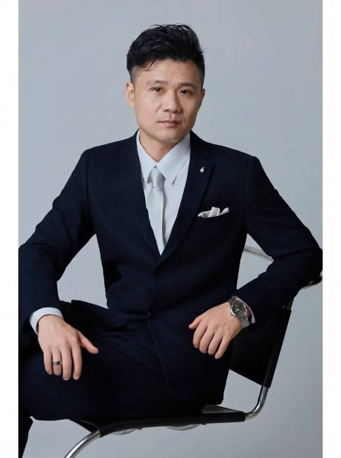 将第一张图片的五官、脸型和发型替换到第二张图片的人物身上，保留第二张图片的深蓝色西装、坐姿姿势、背景和整体构图，保持整体自然协调，写实风格，画质清晰预览效果