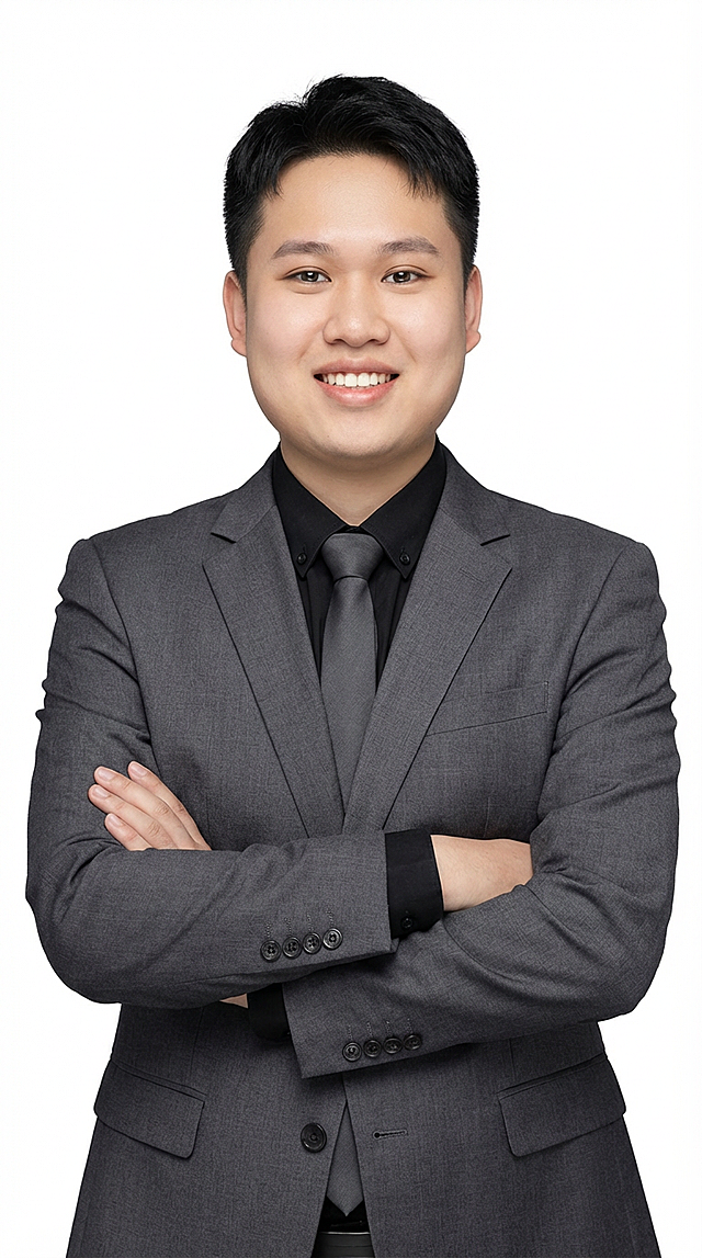 年轻男性穿灰色西装套装（黑衬衫灰色领带），短发利落，从容微笑，双臂交叉，显得专业又亲和。白色底图「图片1」