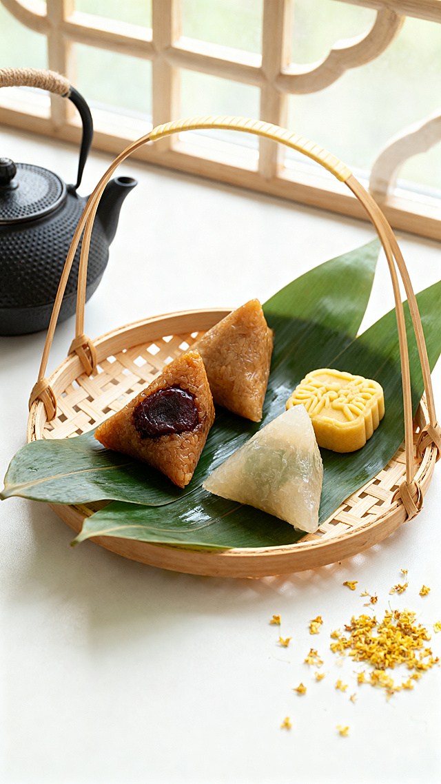 竹编提篮里摆放着蜜枣粽、清水粽和绿豆糕，粽叶铺底，旁边放着茶壶，散落的桂花点缀，窗边柔和自然光，浅景深，干净背景，暖色调，美食商业摄影，高级感，新中式美学，8K 高清，细节细腻，无多余杂物，画面干净，上下留白构图